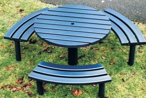 Circular black steel picnic table with horizontal slats and three curved steel horizontal slat benches. 